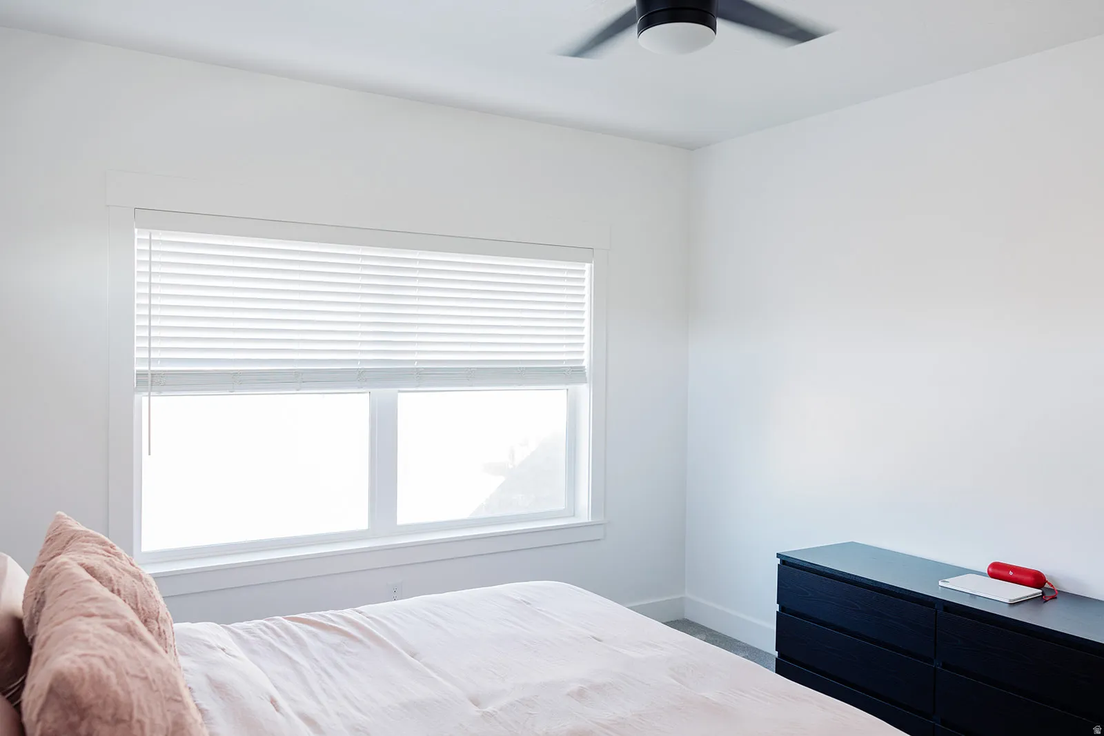White walls and trim throughout, featuring a single window with horizontal blinds