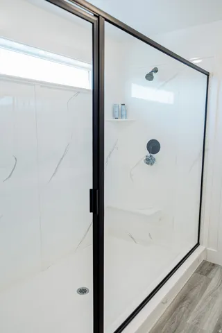 Frameless glass shower enclosure with matte black trim and hardware