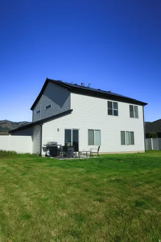Two-story residence featuring white siding and a black shingle roof