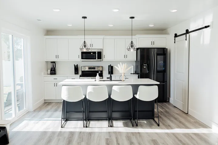 Kitchen with a central island featuring a light-colored countertop and dark base cabinetry