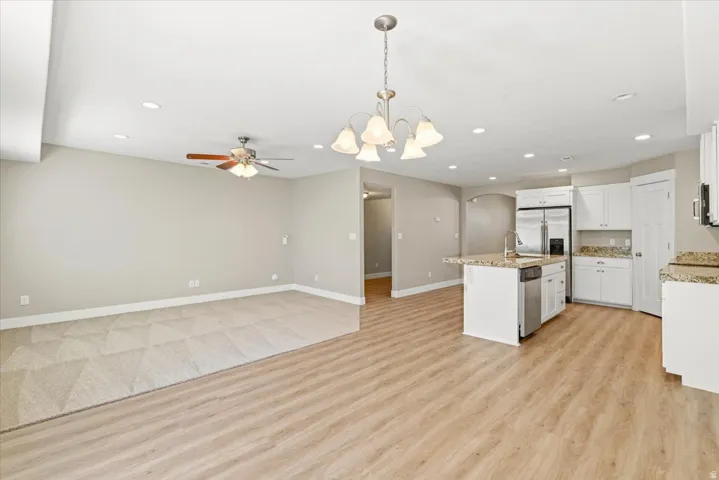 Open-concept living space featuring wood-finish flooring, recessed lighting, and a ceiling fan