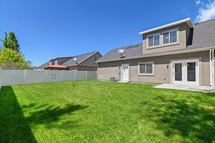 Spacious green lawn enclosed by a white vinyl fence