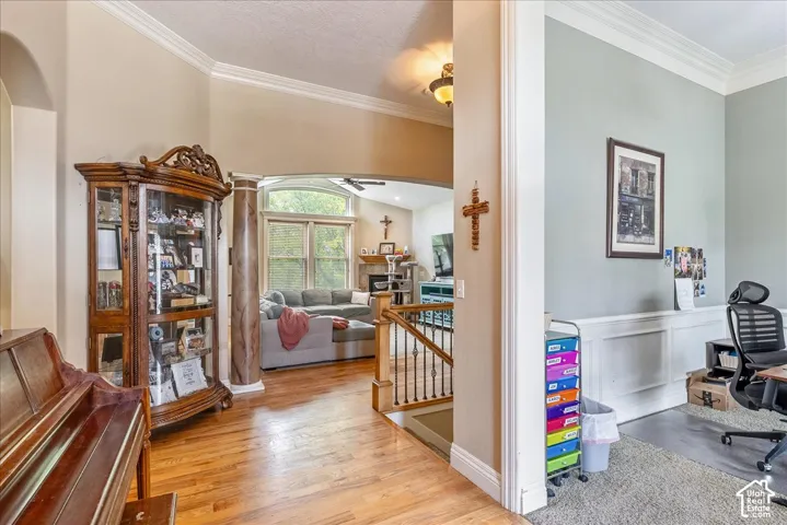 Expansive interior showcasing hardwood flooring, arched doorways, and crown molding
