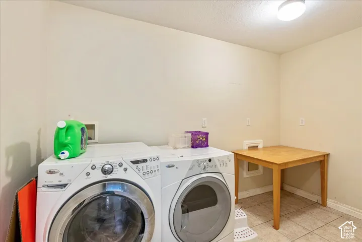 Dedicated utility space featuring light-toned walls and tile flooring