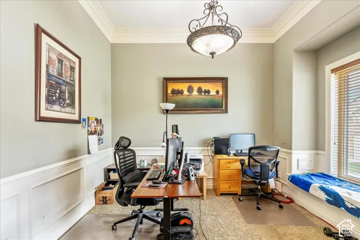 Room featuring crown molding, wainscoting, an ornamental ceiling light fixture, and a window with horizontal blinds