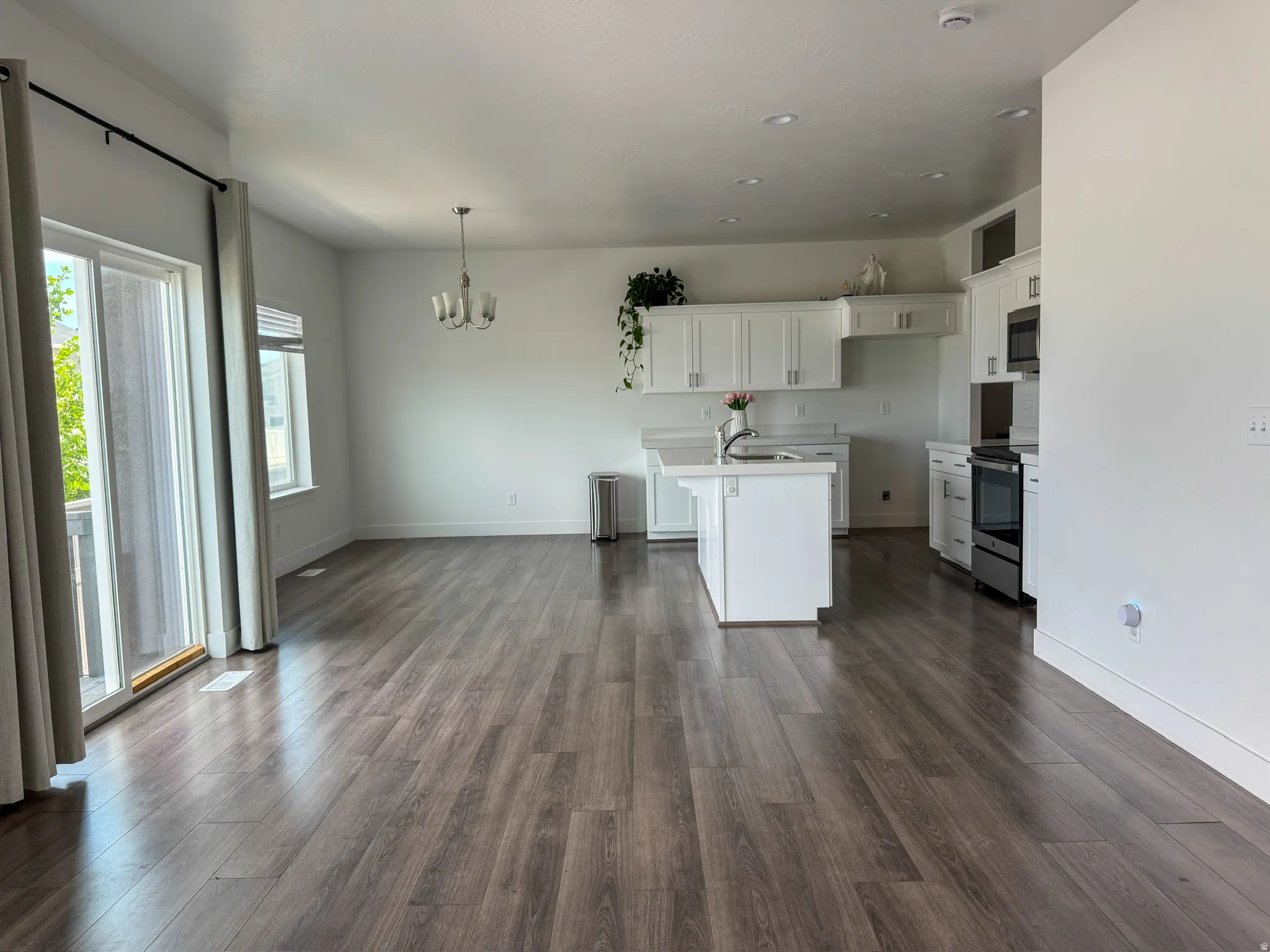 Open concept space featuring wood-finish flooring and a contemporary kitchen