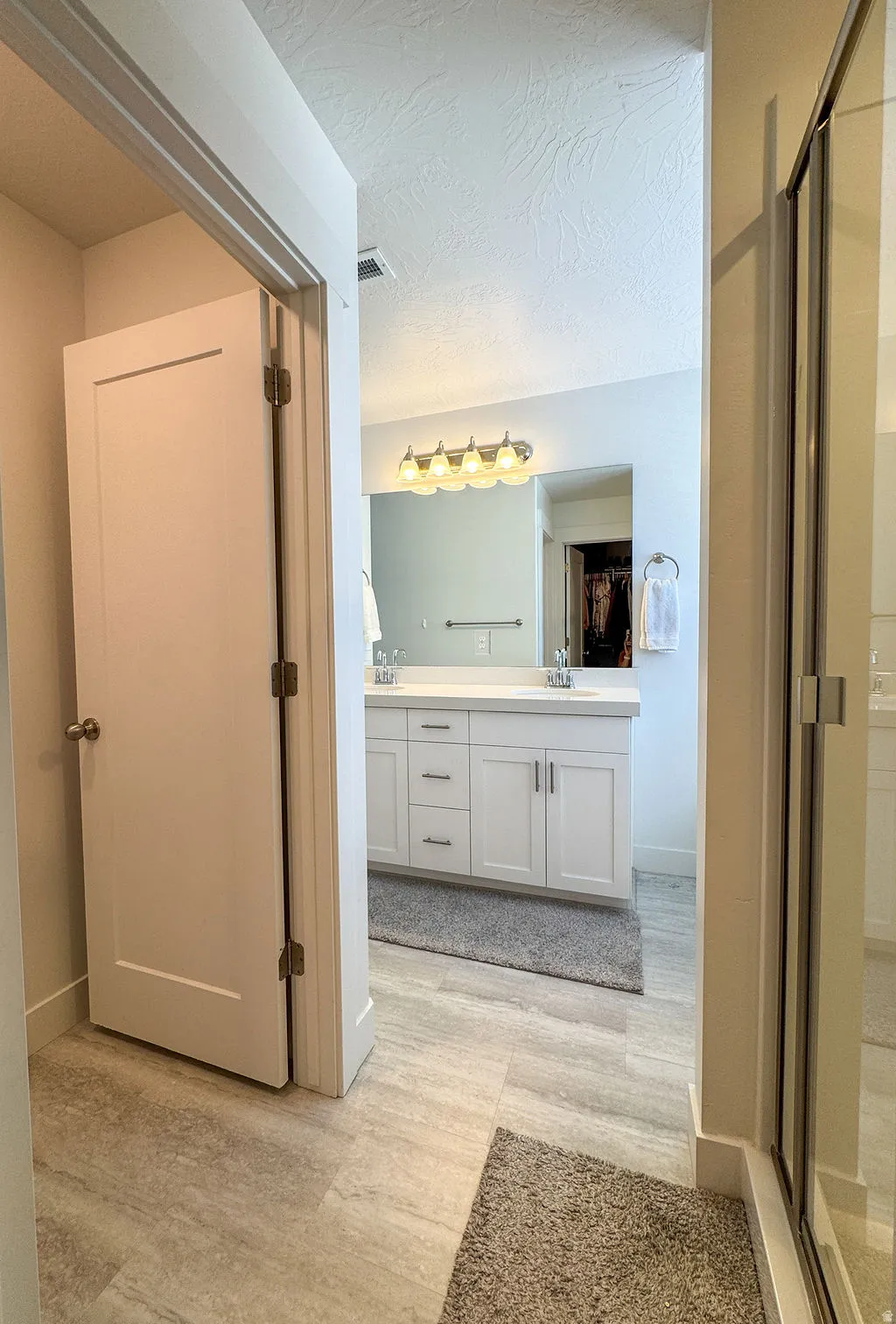 Bathroom featuring a double vanity with white cabinetry, light-colored countertops, and dual undermount sinks