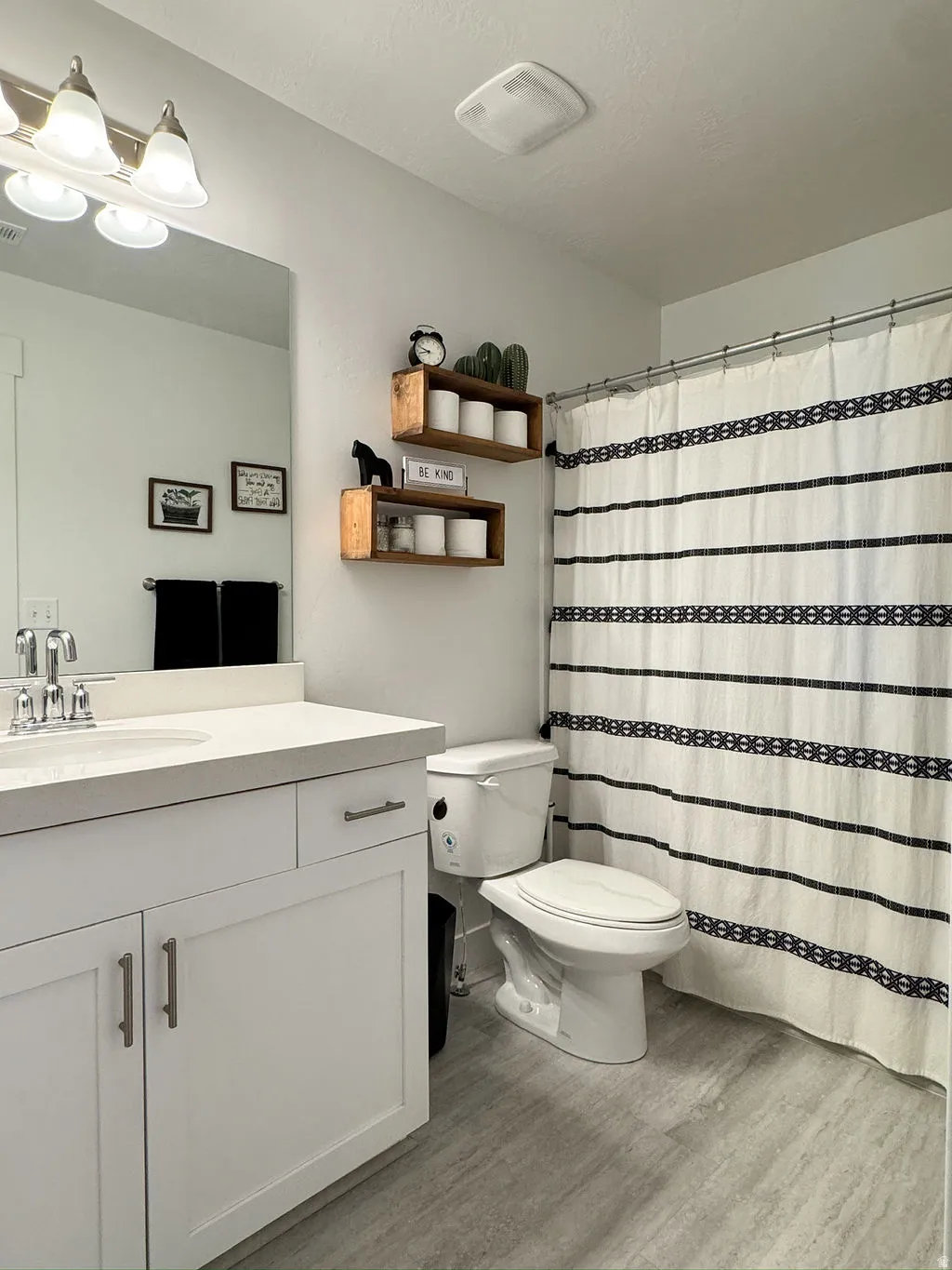 Bathroom featuring a white vanity with a light countertop, chrome faucet, and integrated sink