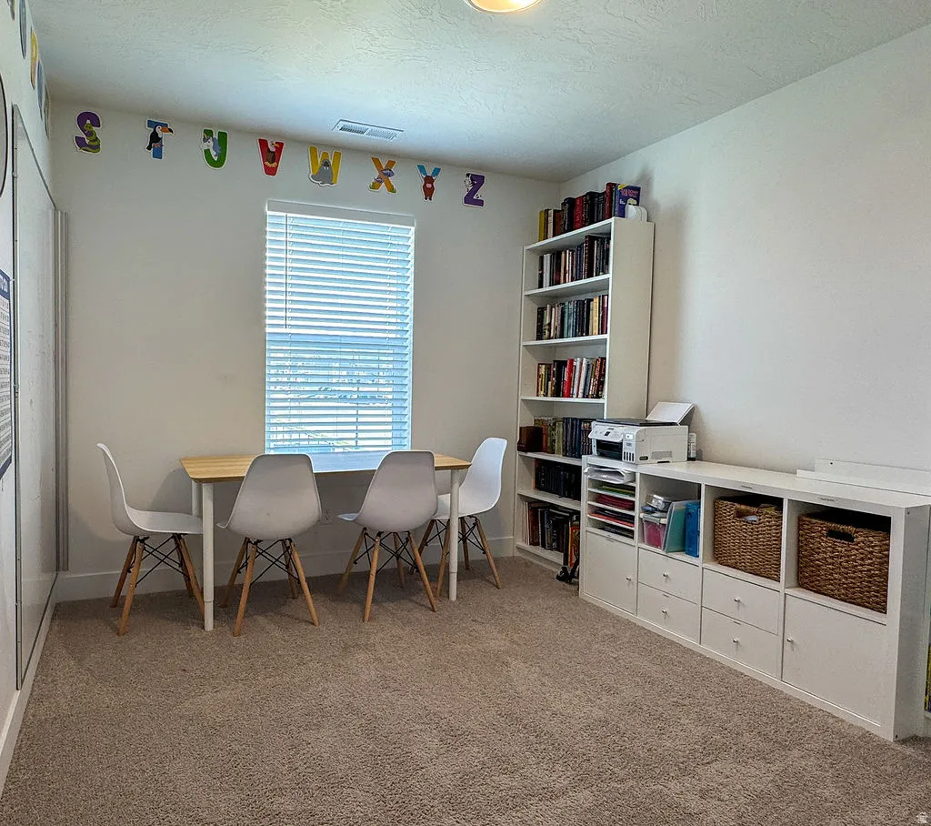 Carpeted room featuring a window with blinds, recessed lighting, and white walls