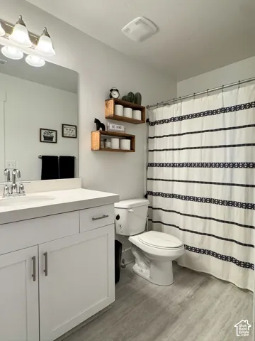 Bathroom featuring a white vanity with a light countertop, chrome faucet, and integrated sink