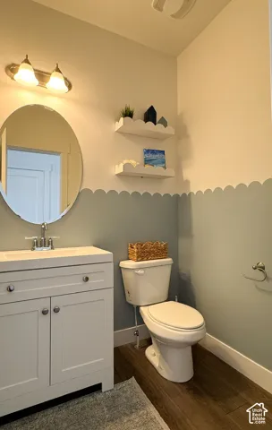 Bathroom featuring a white vanity with a rectangular sink, a polished chrome faucet, and an oval mirror