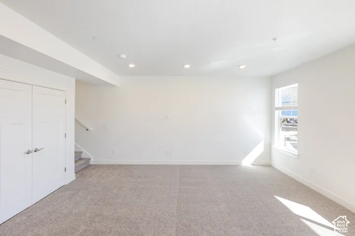 Neutral wall tones, carpeted flooring, recessed ceiling lighting, and double-door closet with paneled detailing