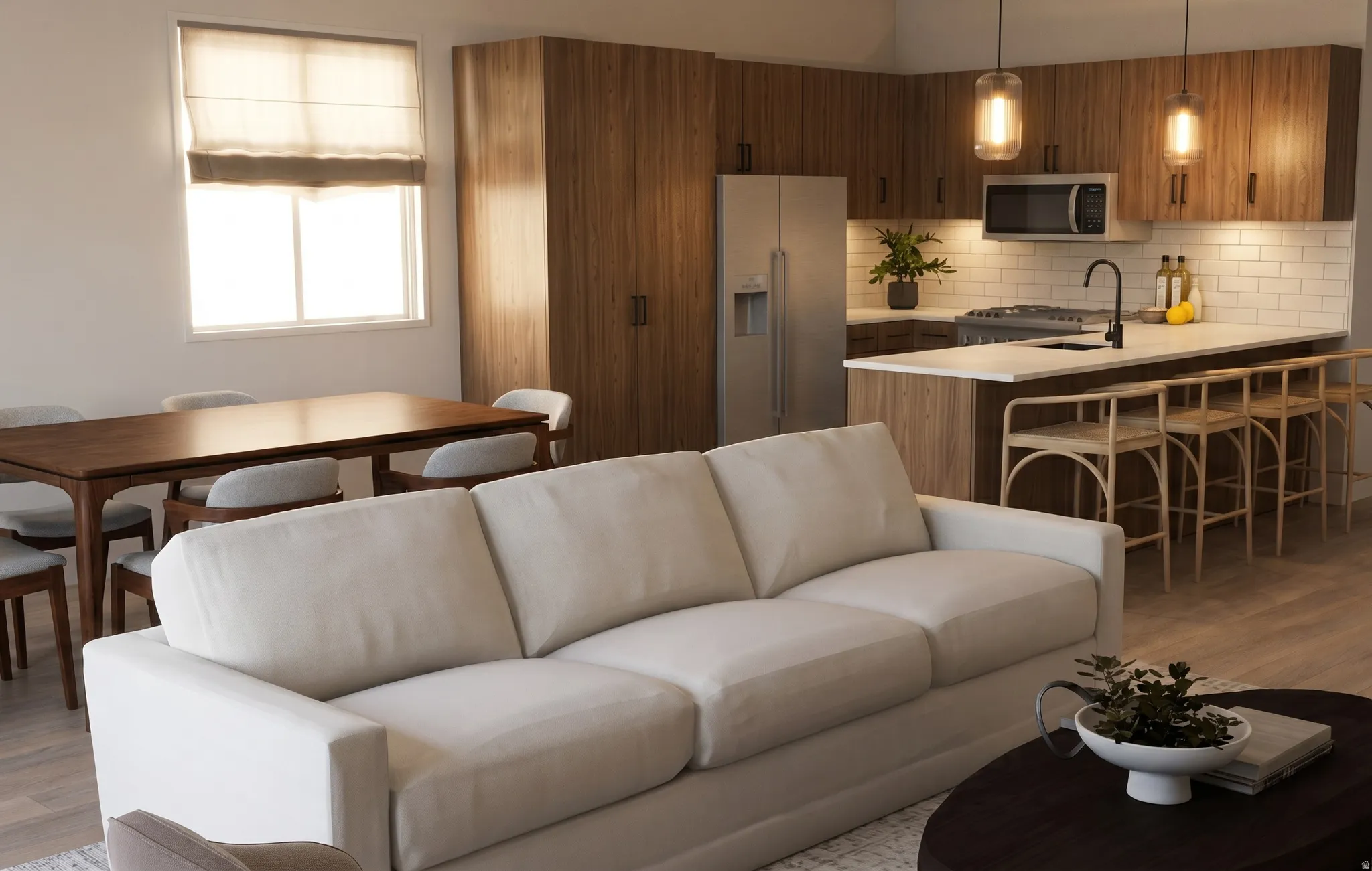 Open-concept living space featuring wood-finish flooring, a contemporary kitchen with stainless steel appliances, white subway tile backsplash, and a breakfast bar