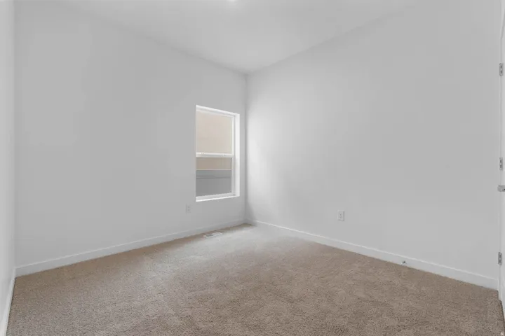 Carpeted room with white walls, a single window, and white baseboards