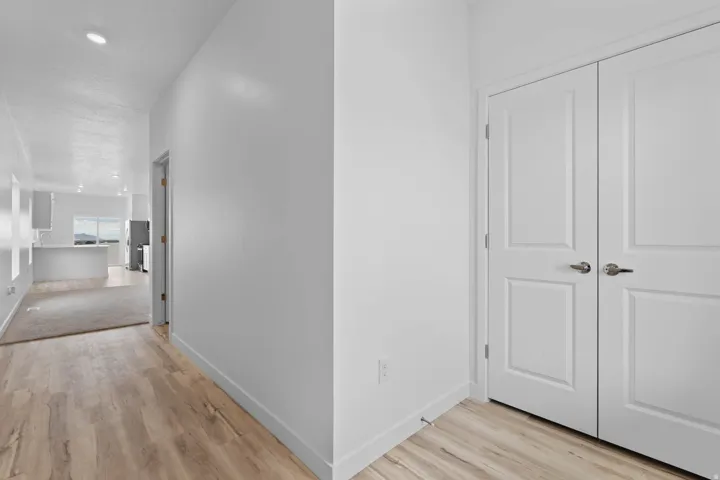 Wood-finish flooring throughout the hallway and a portion of the room