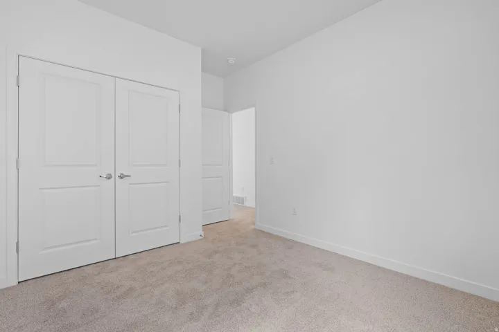 Neutral tone carpeting complemented by crisp white walls and baseboards