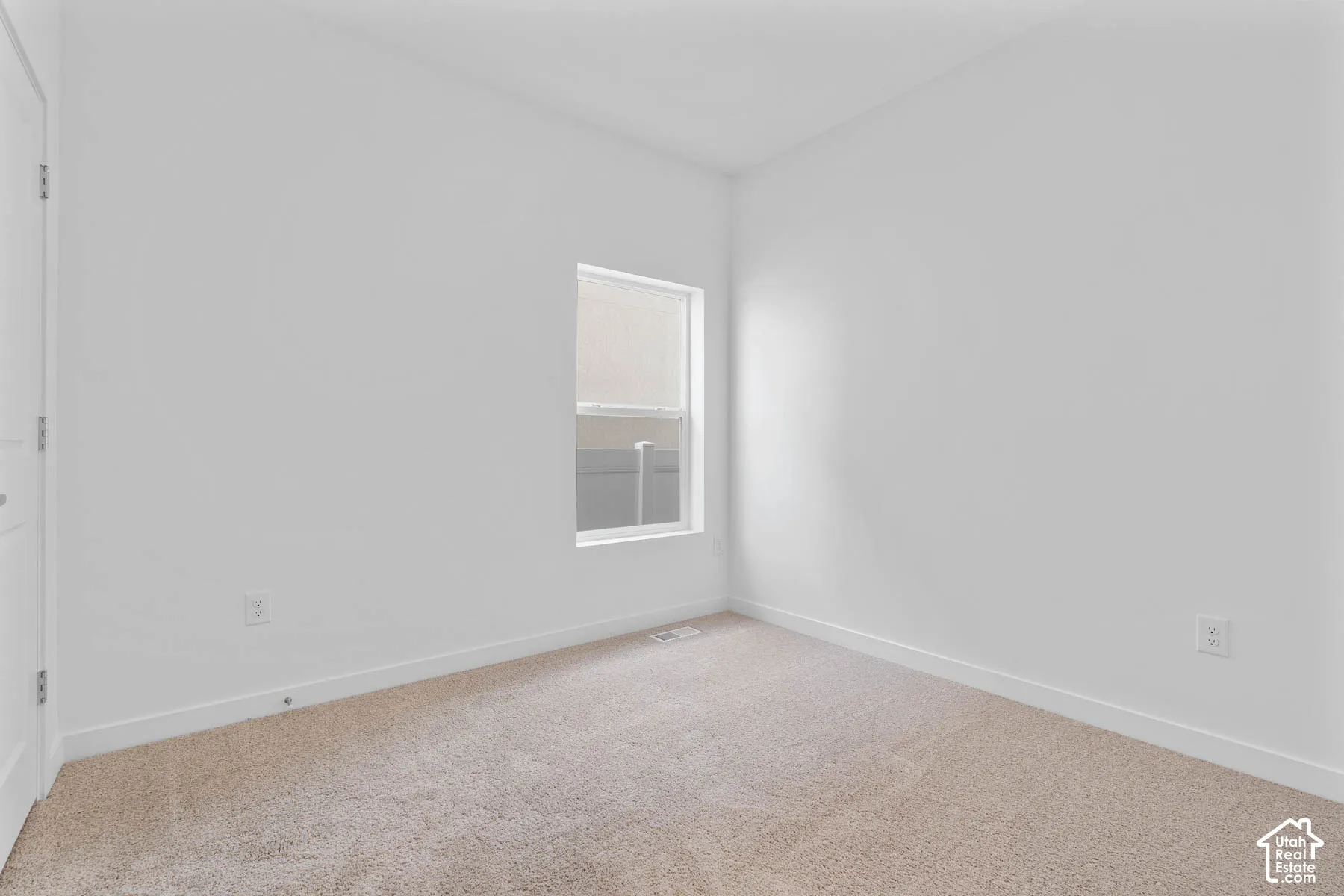 Neutral color palette, window with blinds, light-toned carpet, white walls, white trim