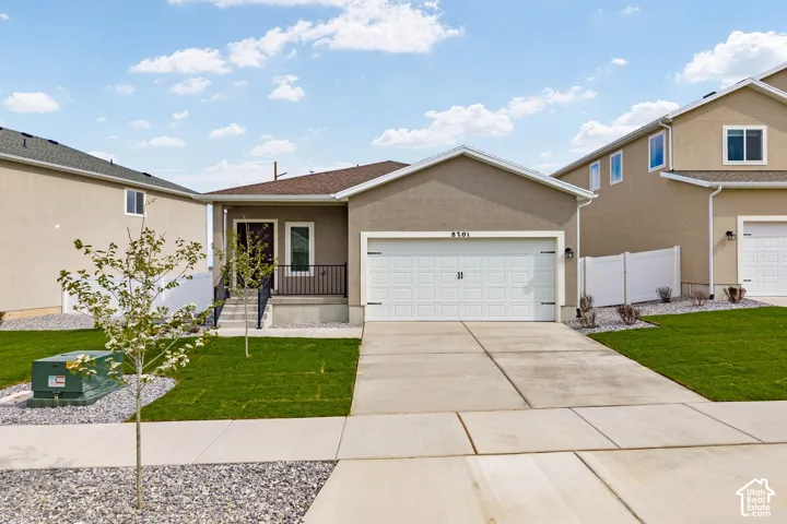 Smooth stucco exterior, attached two-car garage, concrete driveway, and a front porch with black railing