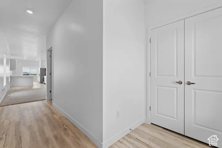 Wood-finish flooring throughout, white interior walls, recessed ceiling lighting, and panel doors with brushed nickel hardware