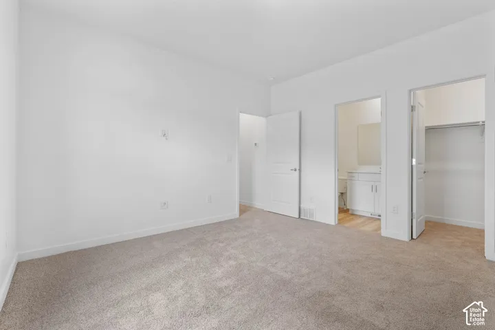 Plush carpeting, neutral wall tones, white interior doors, and recessed lighting