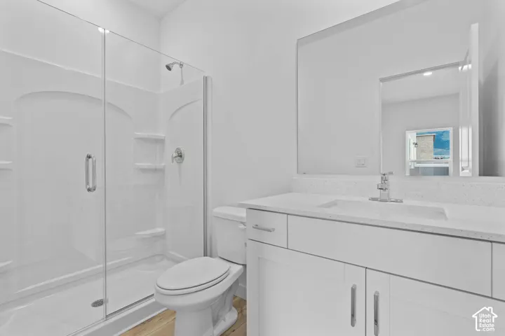 Walk-in shower with clear glass enclosure, white shower surround with integrated shelving, and a chrome shower head