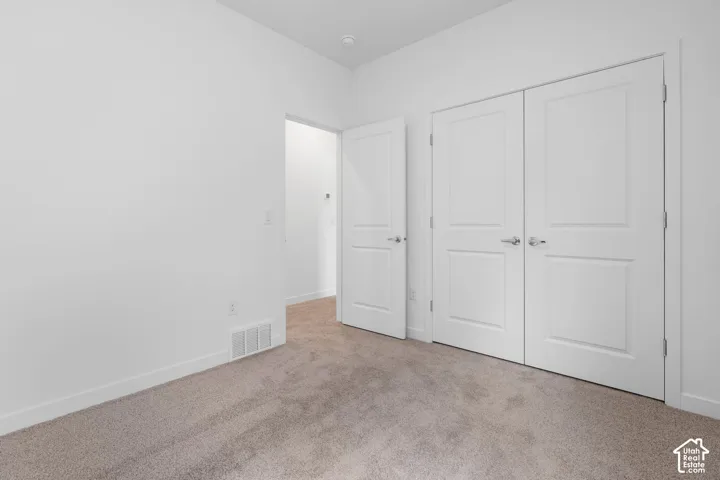 Neutral carpeting with trim, white walls, and white double-panel doors