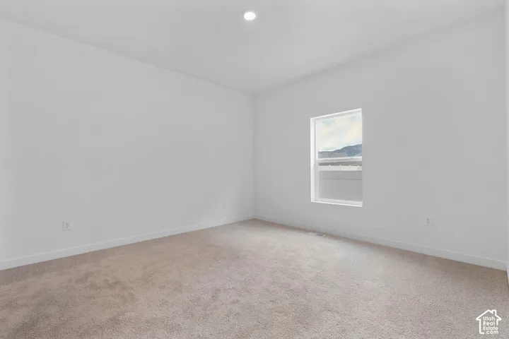 Neutral wall paint, recessed ceiling lighting, light-toned carpet, and a window with white trim