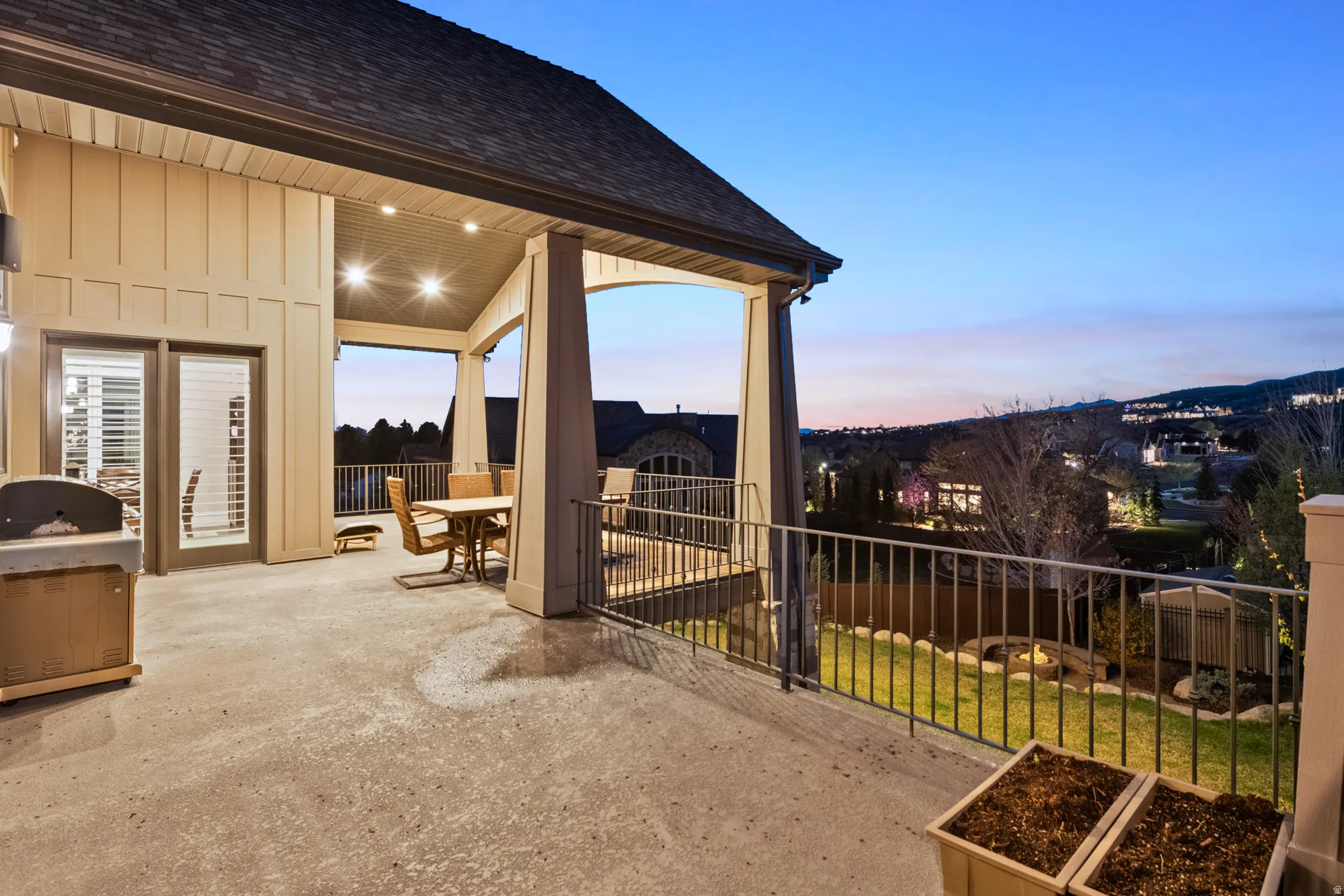 Expansive covered patio featuring concrete flooring, board and batten siding, and a metal railing