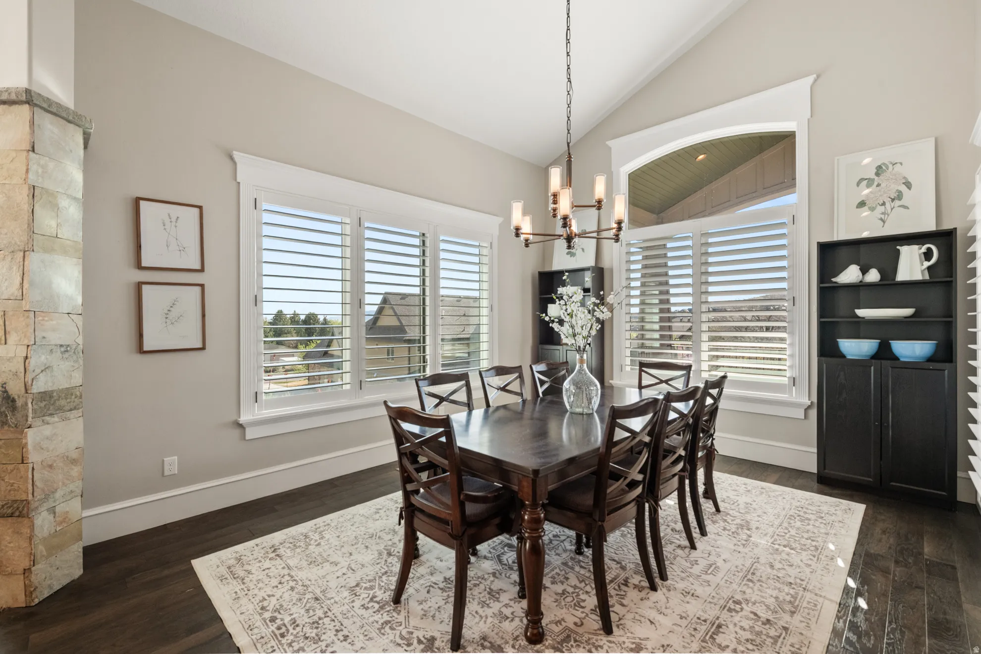 Dining area featuring vaulted ceilings and dark wood-finish flooring