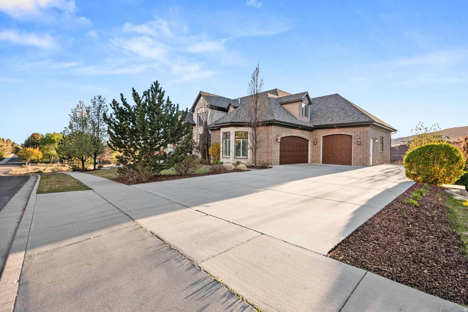 Brick exterior with a multi-gabled roofline and two arched garage doors