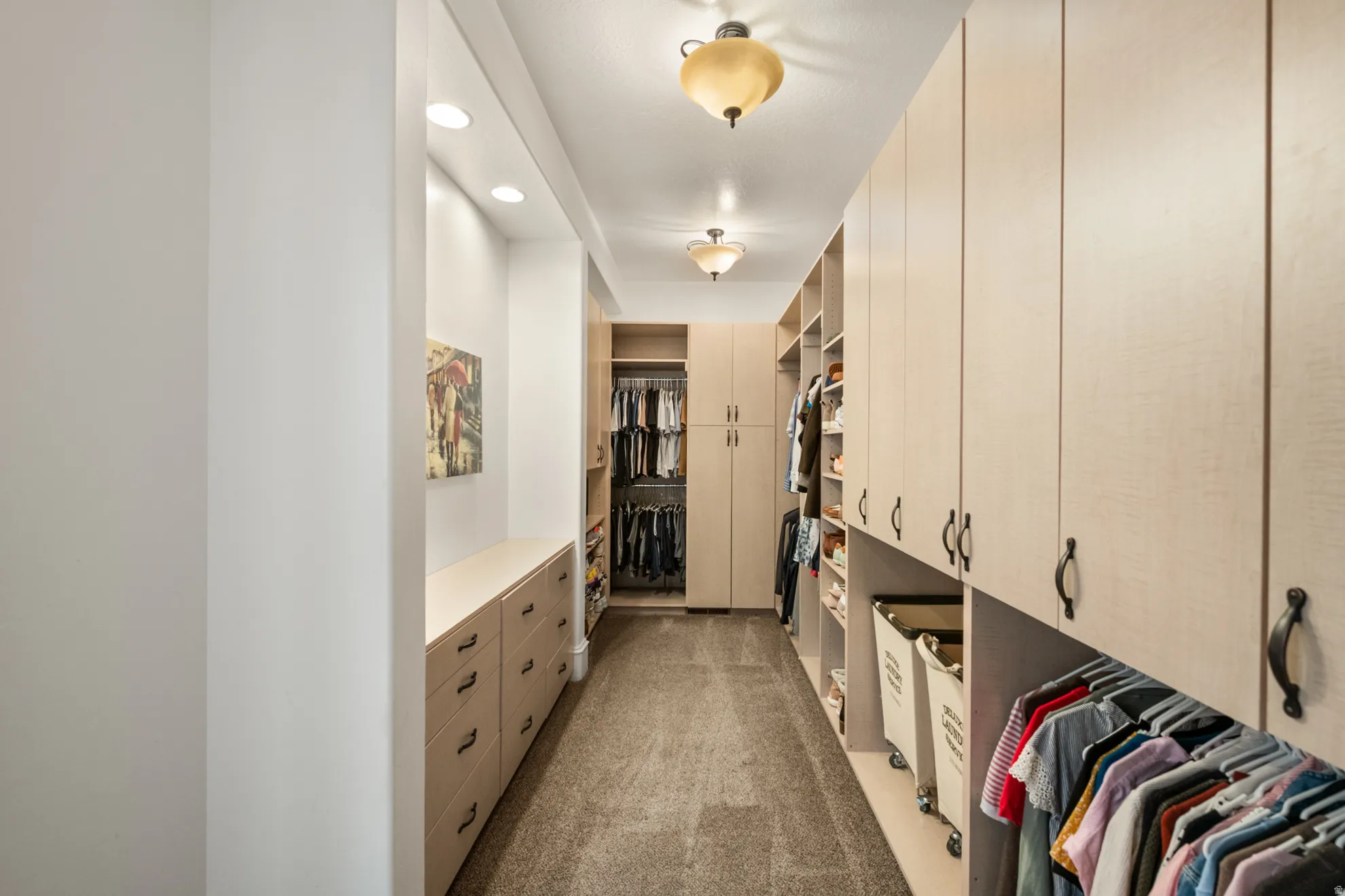 Custom walk-in closet featuring extensive built-in cabinetry, integrated drawers, recessed lighting, and ceiling-mounted fixtures