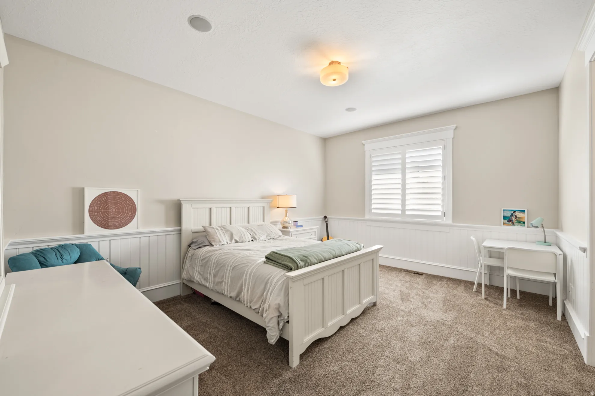 Carpeted room featuring wainscoting, white trim, a window with plantation shutters, and recessed ceiling lighting