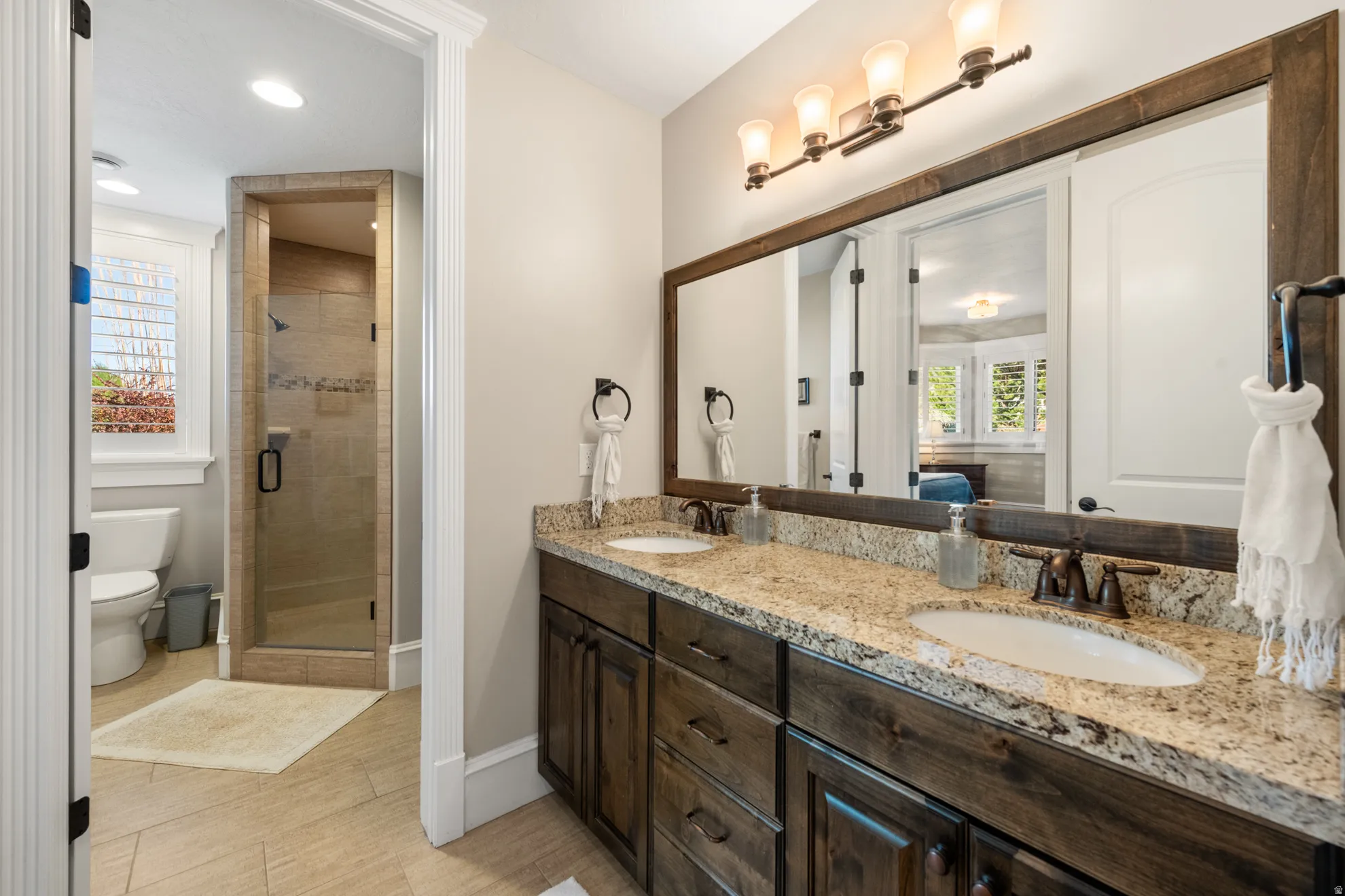 Double vanity with granite countertops and wood-finish cabinetry