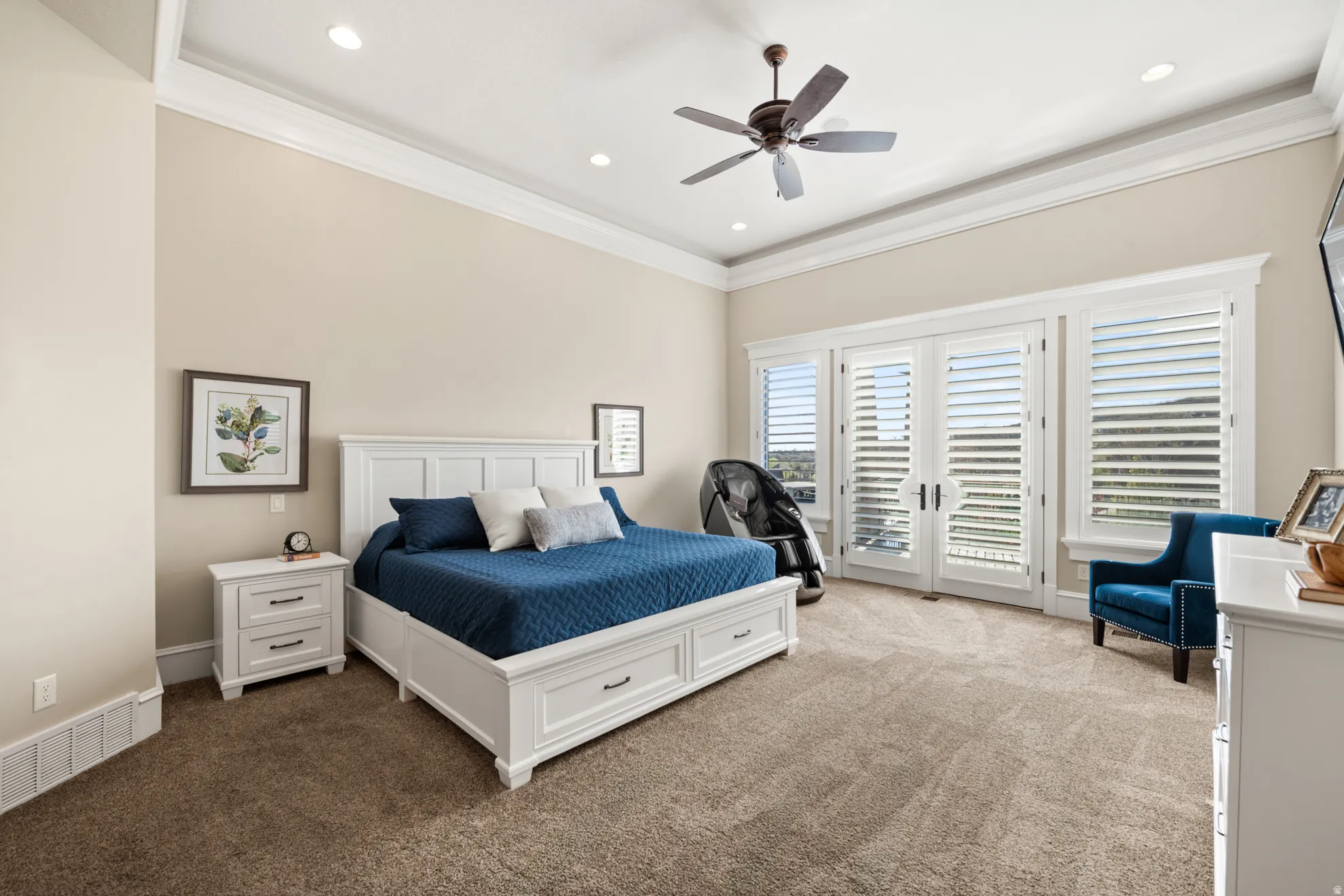 Spacious room featuring vaulted ceilings with recessed lighting, an overhead ceiling fan, and extensive crown molding