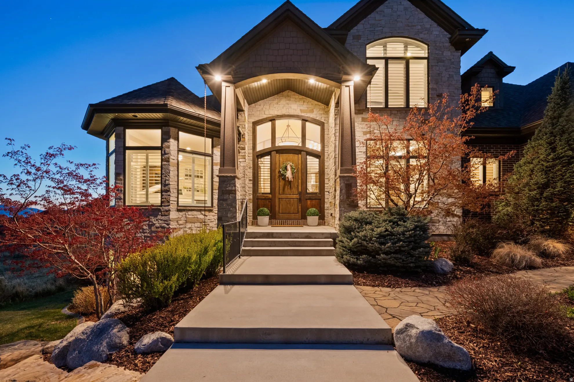 Stone and brick exterior with a prominent arched wooden entry door