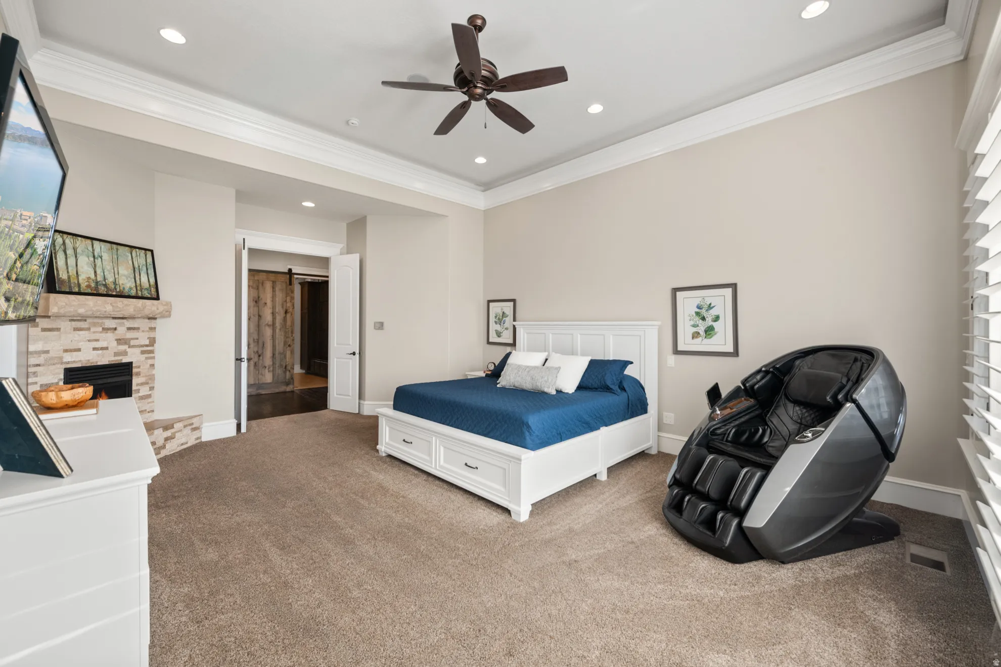 Spacious room featuring tray ceiling, recessed lighting, fireplace with stone surround, and carpet flooring