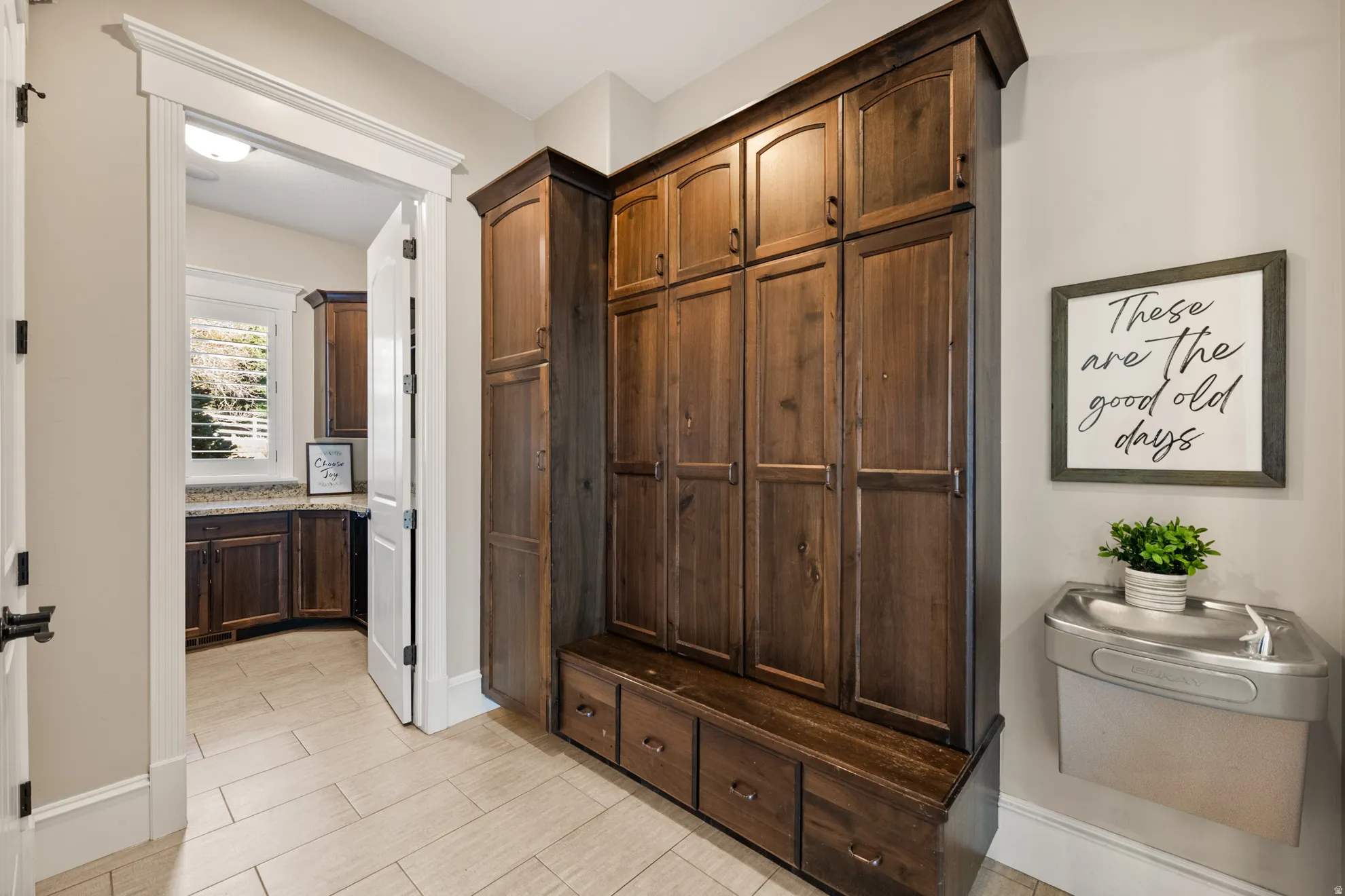 Built-in wood-finish cabinetry featuring storage lockers, bench seating, and lower drawers