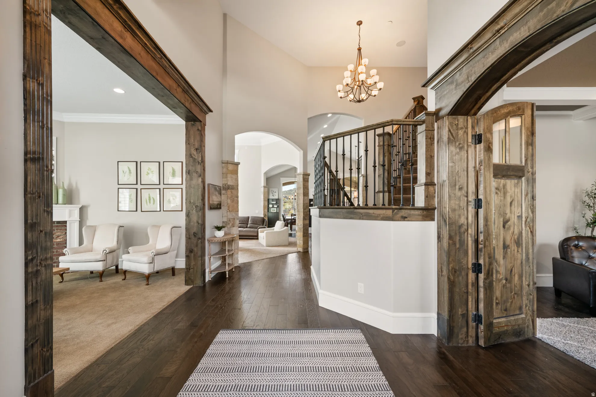 Grand entry foyer with dark wood-finish flooring, a two-story ceiling, and a chandelier