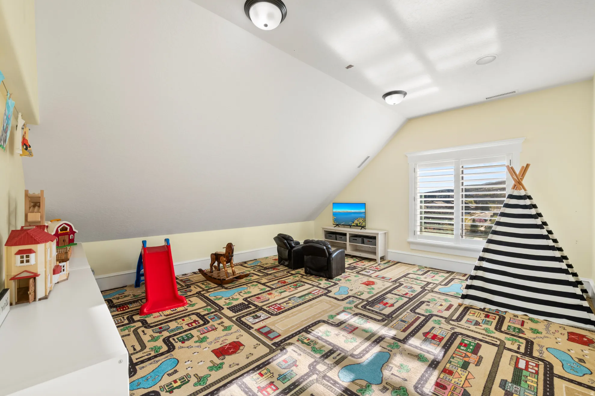 Attic room featuring a sloped ceiling, light yellow walls, and recessed lighting