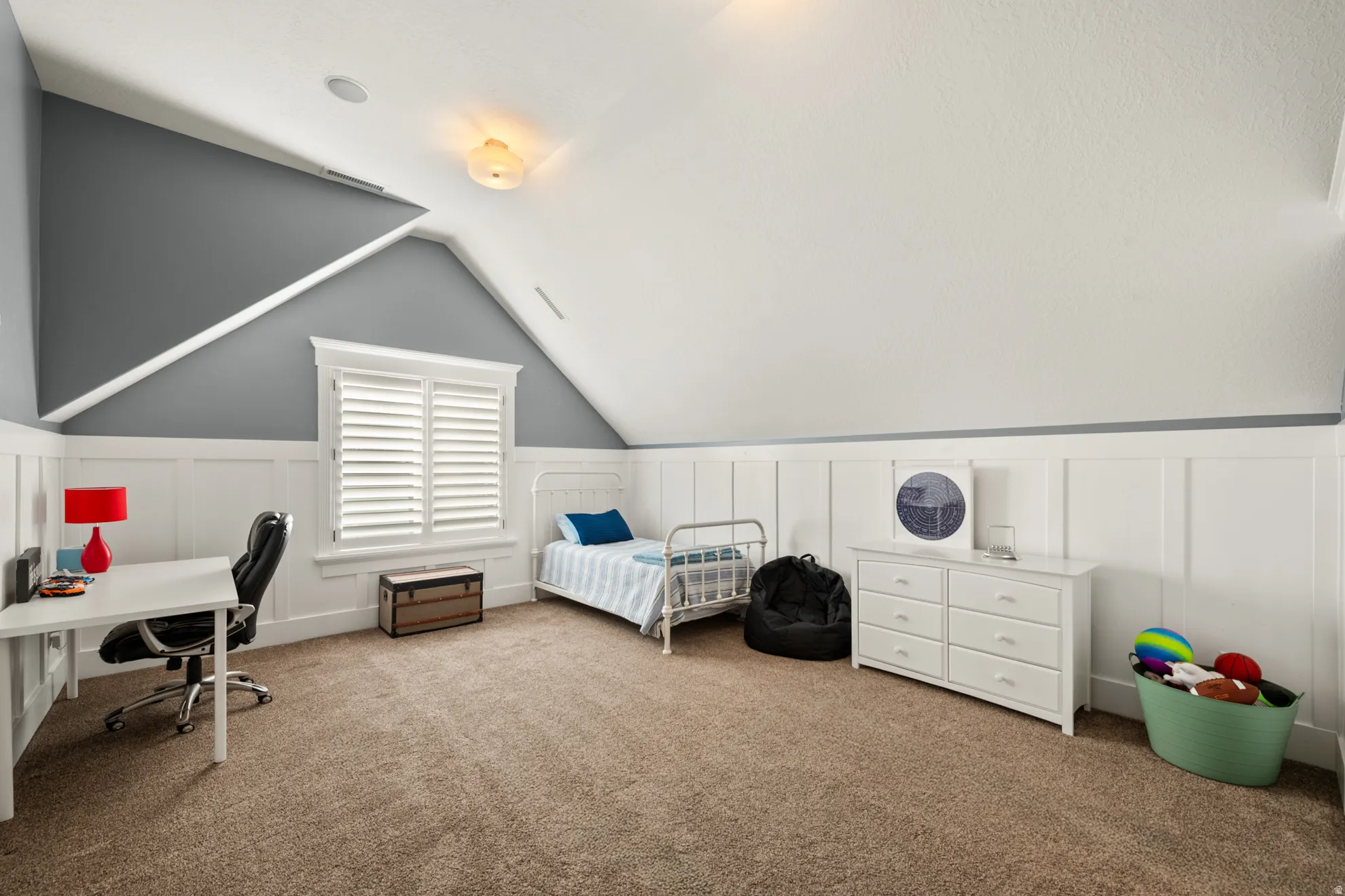 Carpeted room featuring a window with white plantation shutters, board and batten wainscoting, and a sloped ceiling with recessed lighting