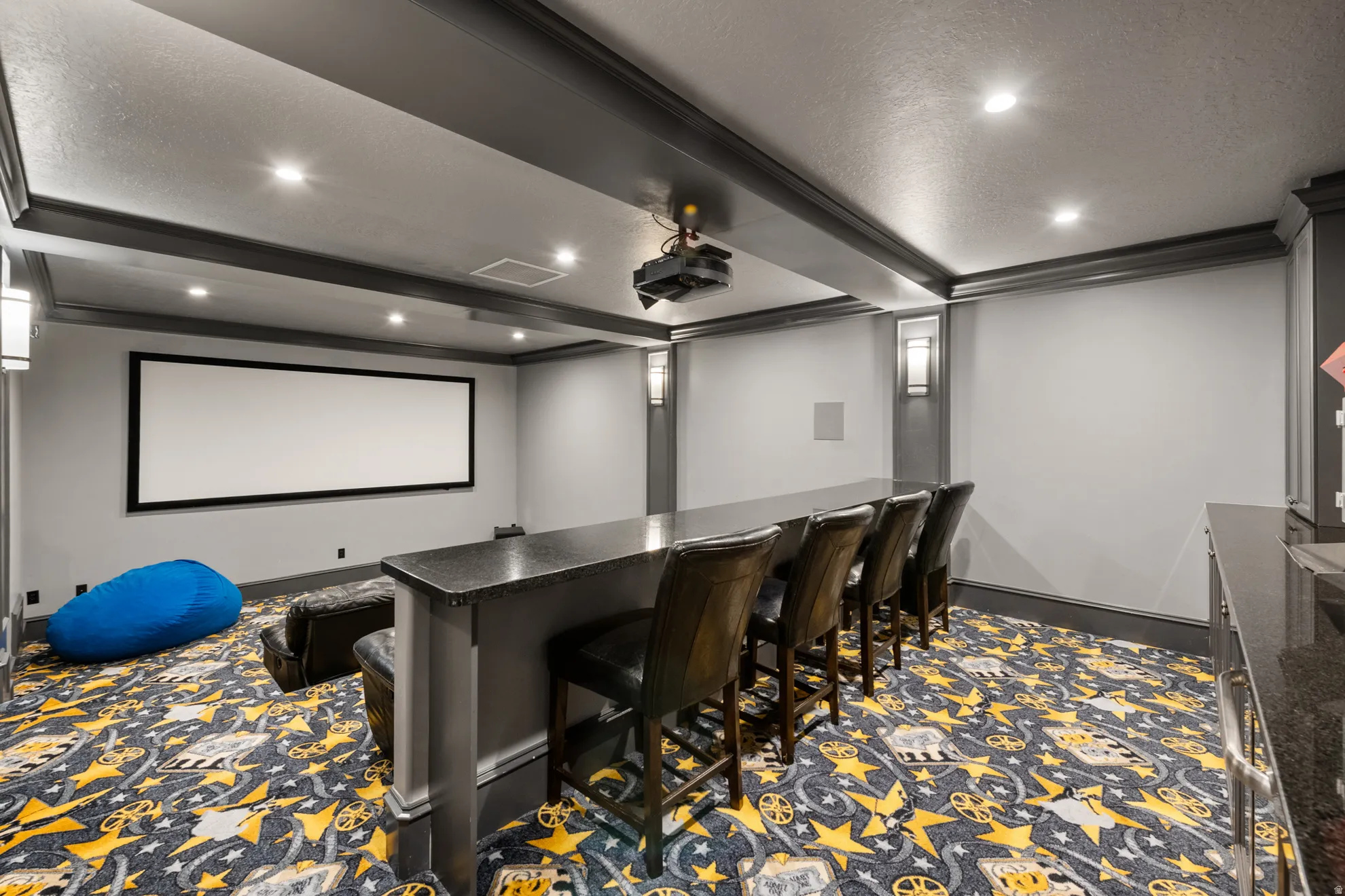 Dedicated entertainment room featuring a large projection screen and ceiling-mounted projector