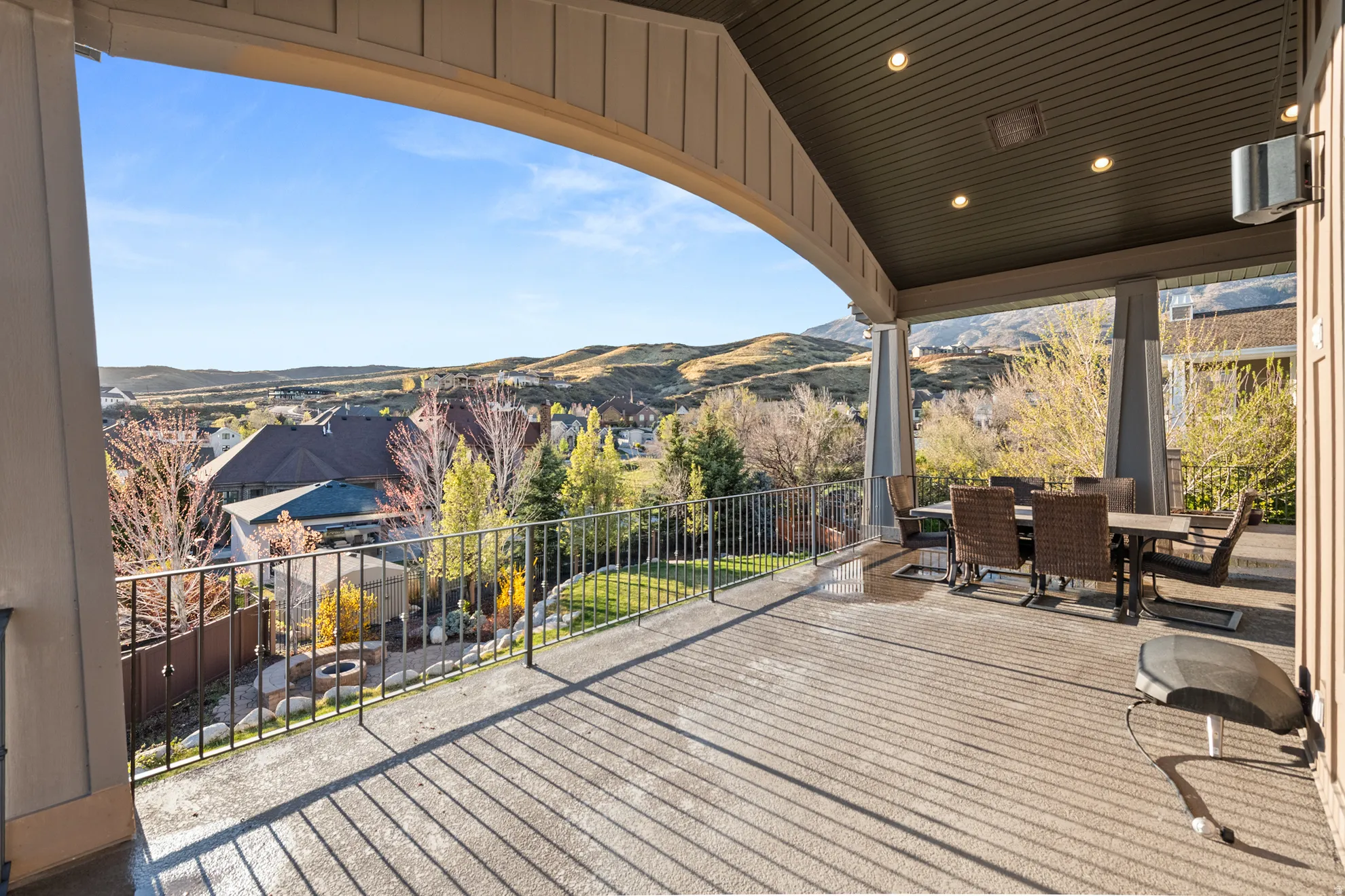 Expansive covered patio featuring a concrete surface, recessed lighting, and an arched beam structure