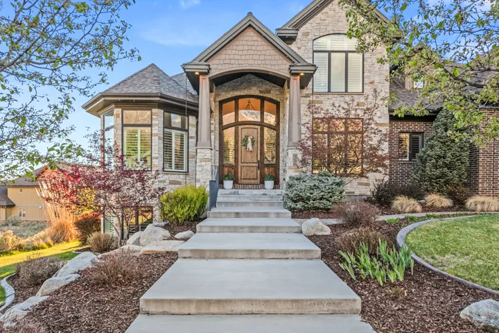 Stone and brick exterior with a prominent arched entry and decorative wood door