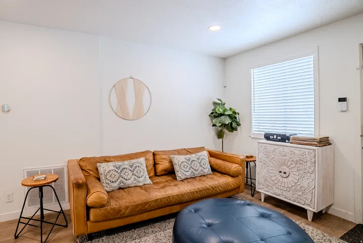 Bright room featuring a window with horizontal blinds, recessed ceiling lighting, wood-finish flooring, and a floor vent
