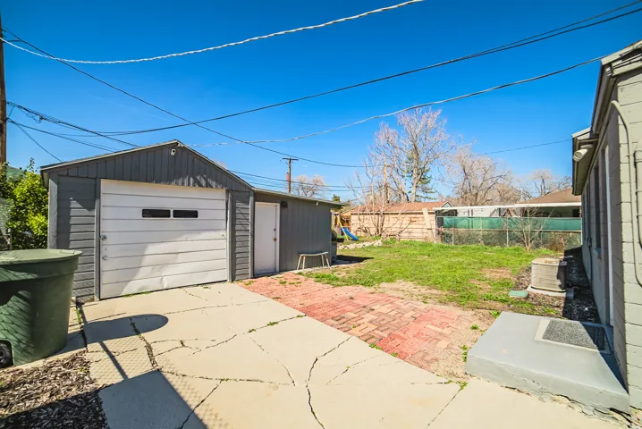 Detached garage structure with a white overhead door and side entry