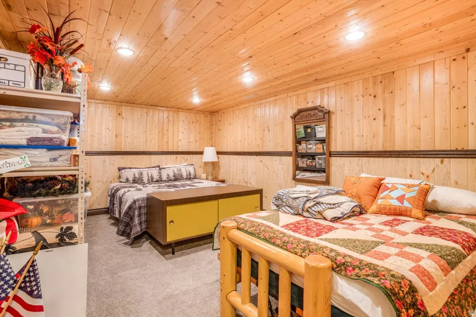 Wood-paneled walls and ceiling creating a rustic ambiance, complemented by recessed lighting and a carpeted floor