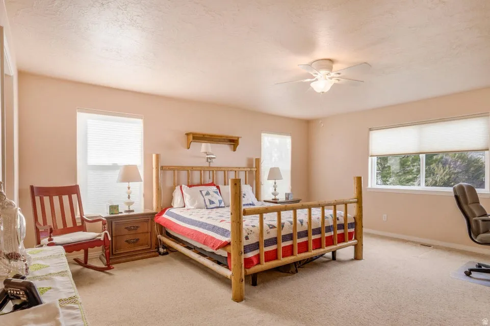 Spacious bedroom with light-toned walls and carpet flooring