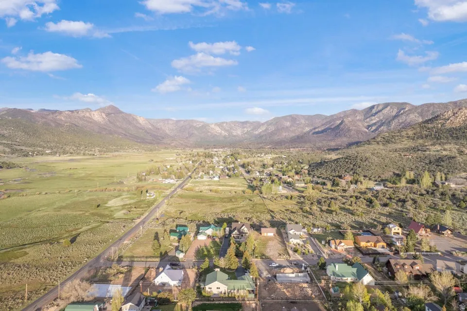 Aerial perspective showcasing a residential area nestled within a expansive valley, framed by prominent mountains