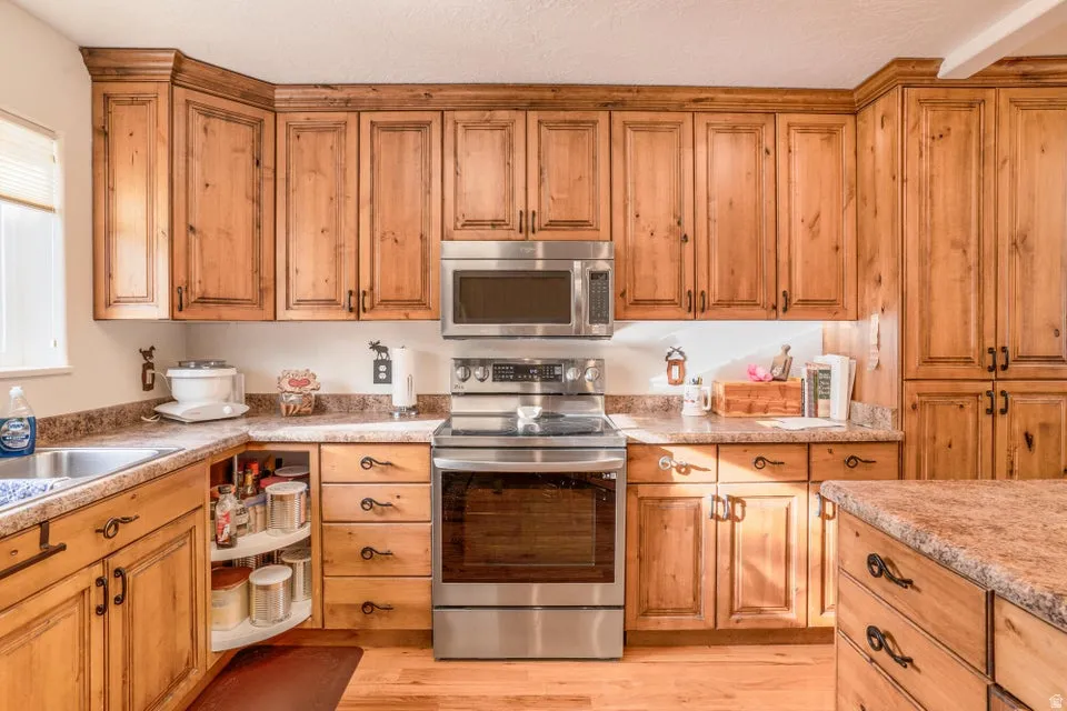 Kitchen featuring extensive wood-finish cabinetry, stainless steel appliances, and durable laminate countertops