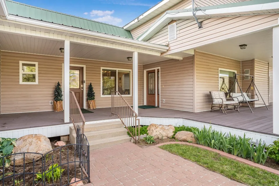 Front porch entry with a metal roof and tan siding